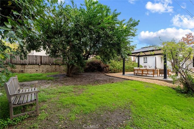 a view of a chair and table in backyard of the house