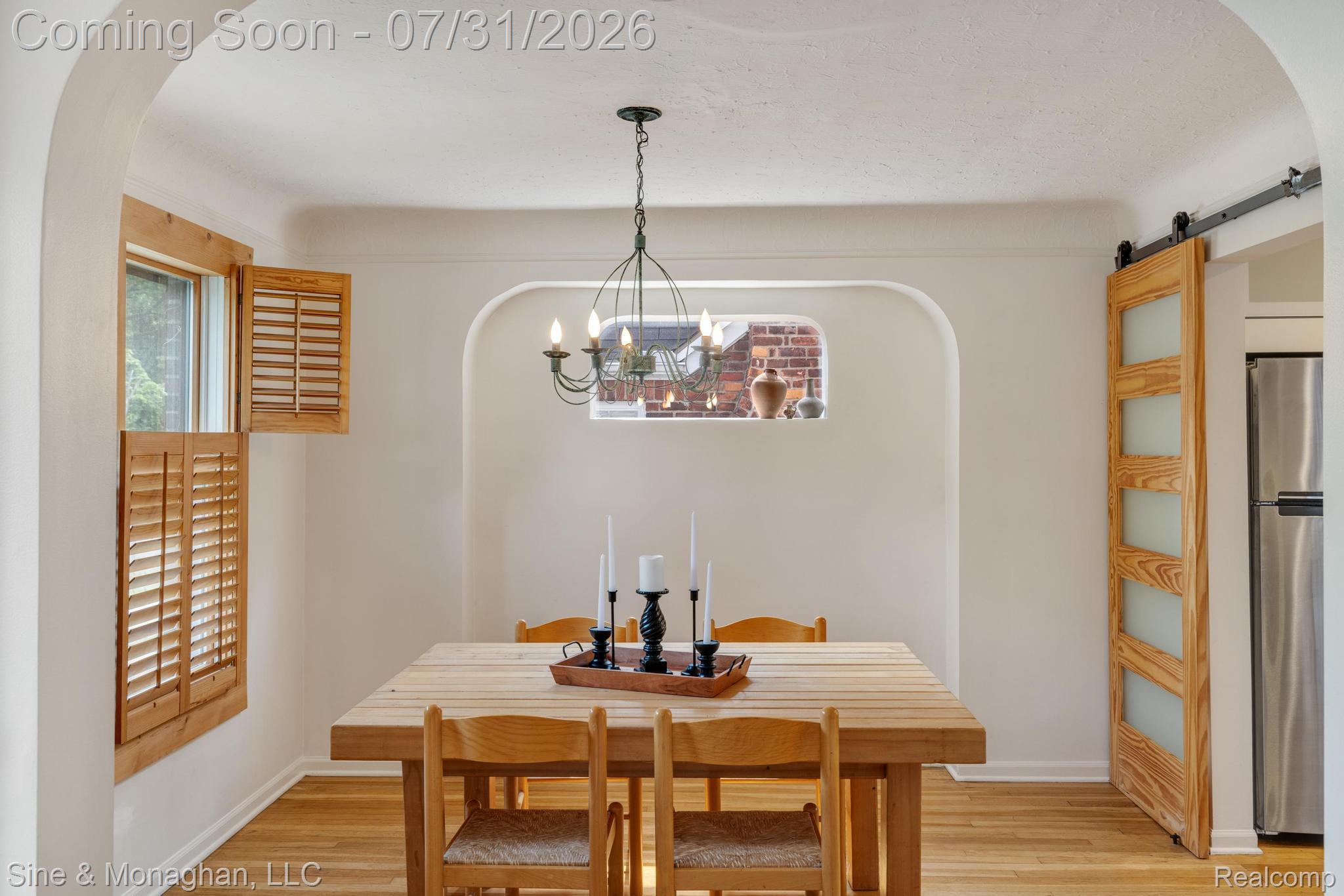 417 Cloverly Road Grosse Pointe, MI 48236 - Photo 24 of 70 Dining area featuring wood-finish flooring, a contemporary chandelier, and arched doorways