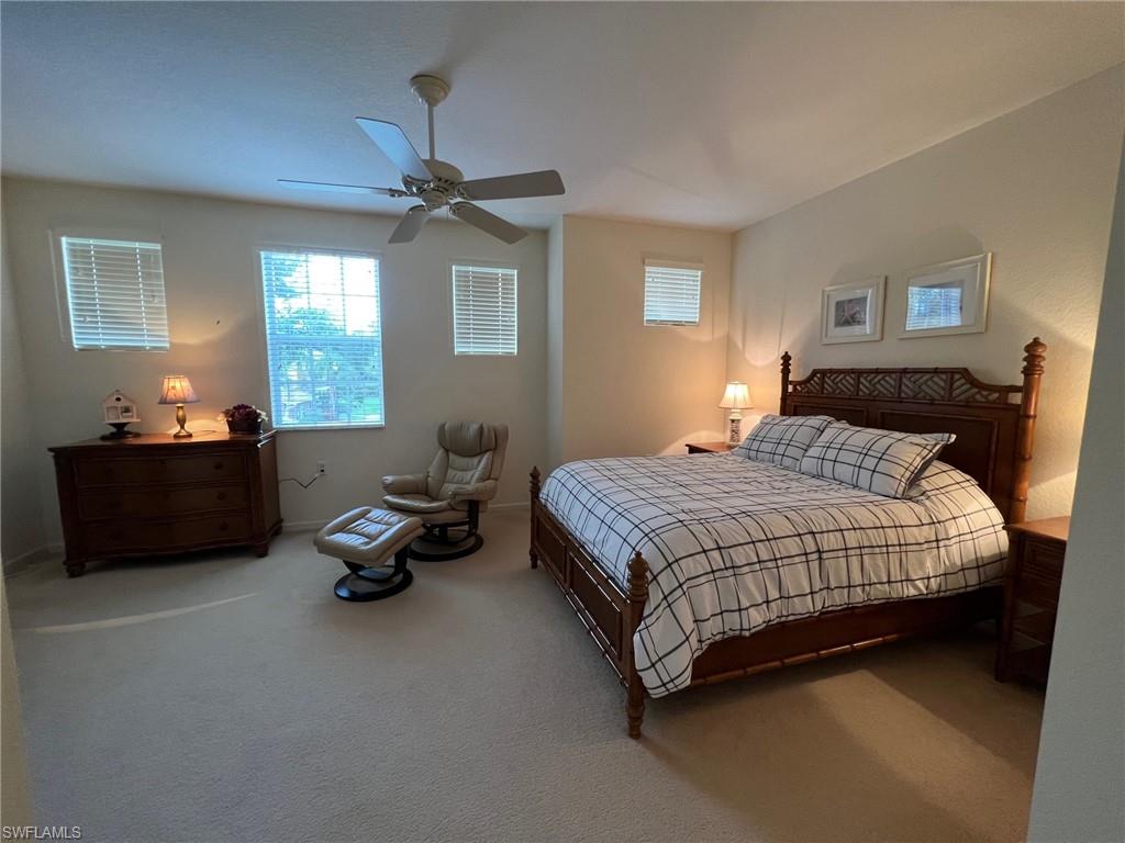 6821 Ascot Drive, Unit 202 Naples, FL 34113 - Photo 15 of 35 a bedroom with a bed and a chandelier