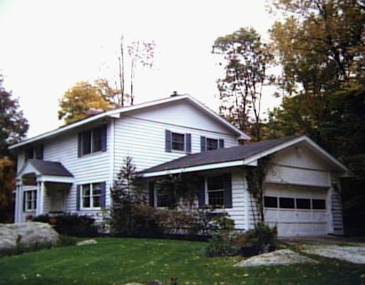 56 Teapot Hill Road Wilton, CT 06897 - Photo 1 of 1 a front view of a house with a yard and potted plants