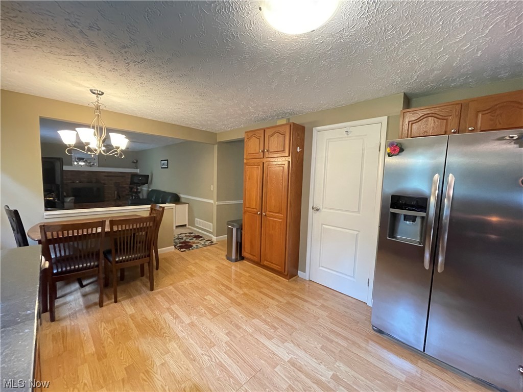 9572 Hoose Road Mentor, OH 44060 - Photo 18 of 35 Kitchen featuring pendant lighting, an inviting chandelier, light flooring, and stainless steel refrigerator with ice dispenser