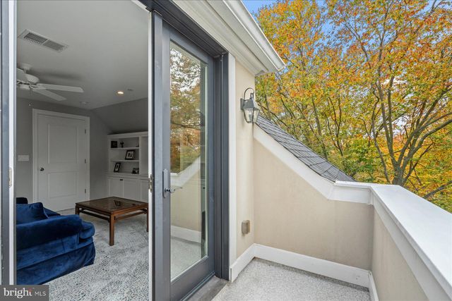 a white bench sitting in the grass near a tree