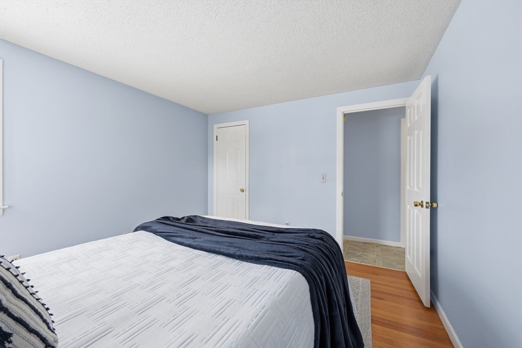 176 Silvin Road Chicopee, MA 01013 - Photo 15 of 32 a bedroom with a bed and wooden floor
