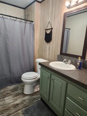 a bathroom with a granite countertop sink toilet and a mirror