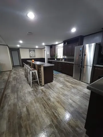 a kitchen with stainless steel appliances wooden floor and refrigerator