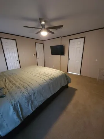 a spacious bedroom with a bed and lamp