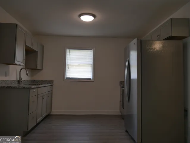 a kitchen with granite countertop a refrigerator and a sink