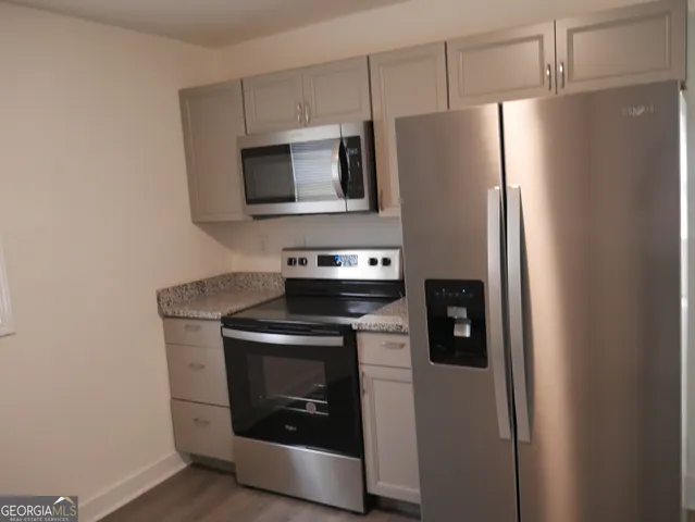 a kitchen with stainless steel appliances a stove microwave and refrigerator
