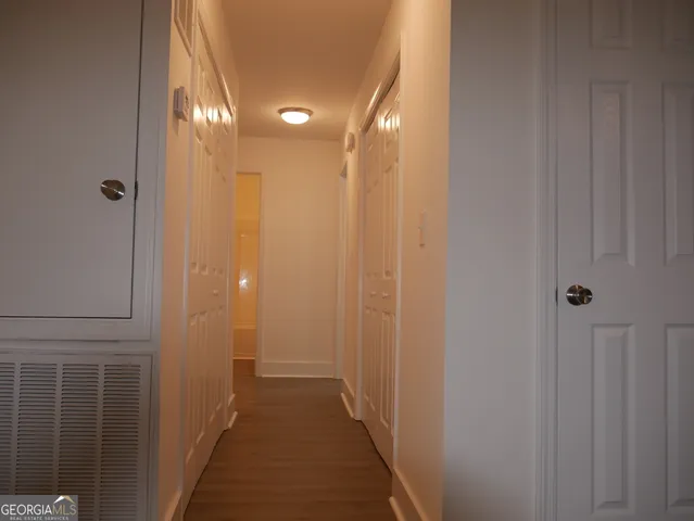 a view of a hallway with shower and a door
