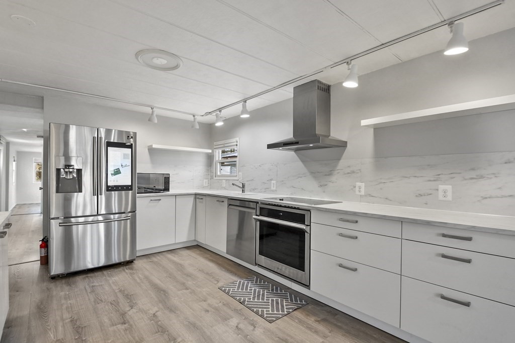 a kitchen with stainless steel appliances granite countertop a refrigerator and a sink