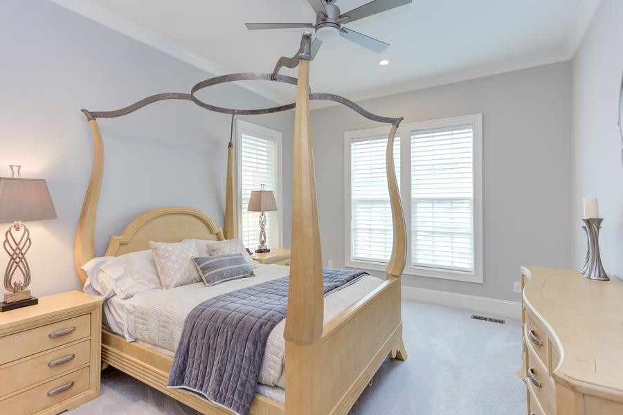 1017 Bradburn Drive Durham, NC 27713 - Photo 16 of 34 a bedroom with a large bed and a chandelier