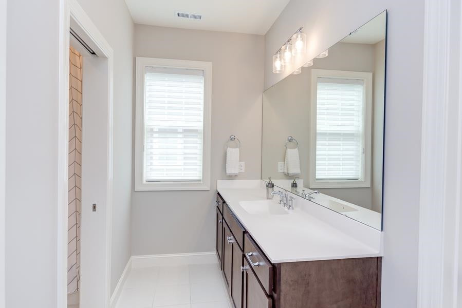 1017 Bradburn Drive Durham, NC 27713 - Photo 29 of 34 a bathroom with a sink a vanity and a mirror