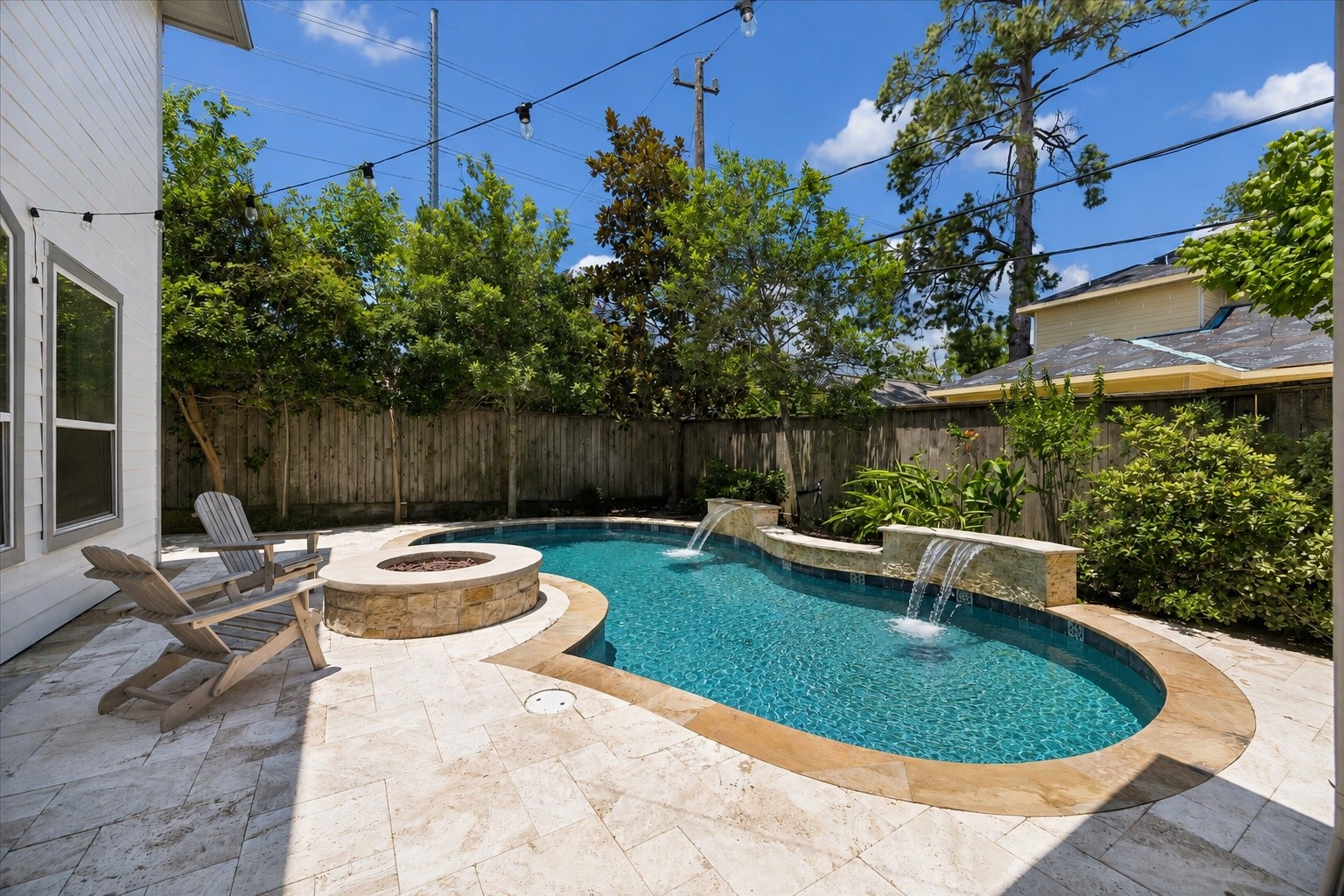 1360 Chippendale Road Houston, TX 77018 - Photo 26 of 34 Resort-style backyard retreat centered around a sparkling pool with sun shelf and water features, installed in 2017. Built-in outdoor fireplace creates a warm gathering space while the surrounding patio provides ample room for lounging and entertaining.