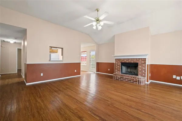 a view of a livingroom with wooden floor and a fireplace