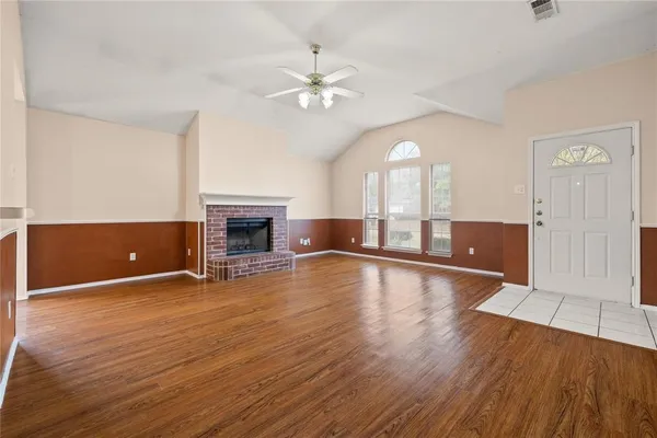 a view of a livingroom with wooden floor and a fireplace