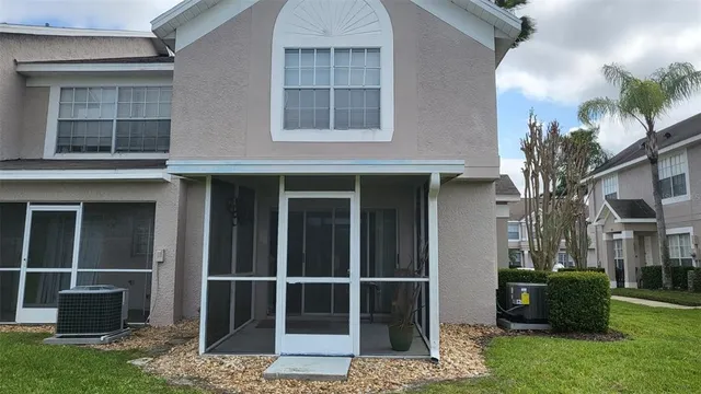 a view of brick house with a large windows and a yard