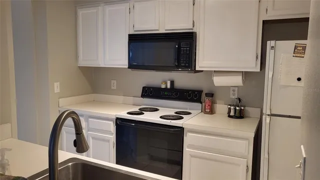 a kitchen with stainless steel appliances granite countertop a stove and a microwave with cabinets