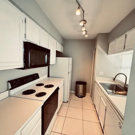 a kitchen with a sink a stove and cabinets