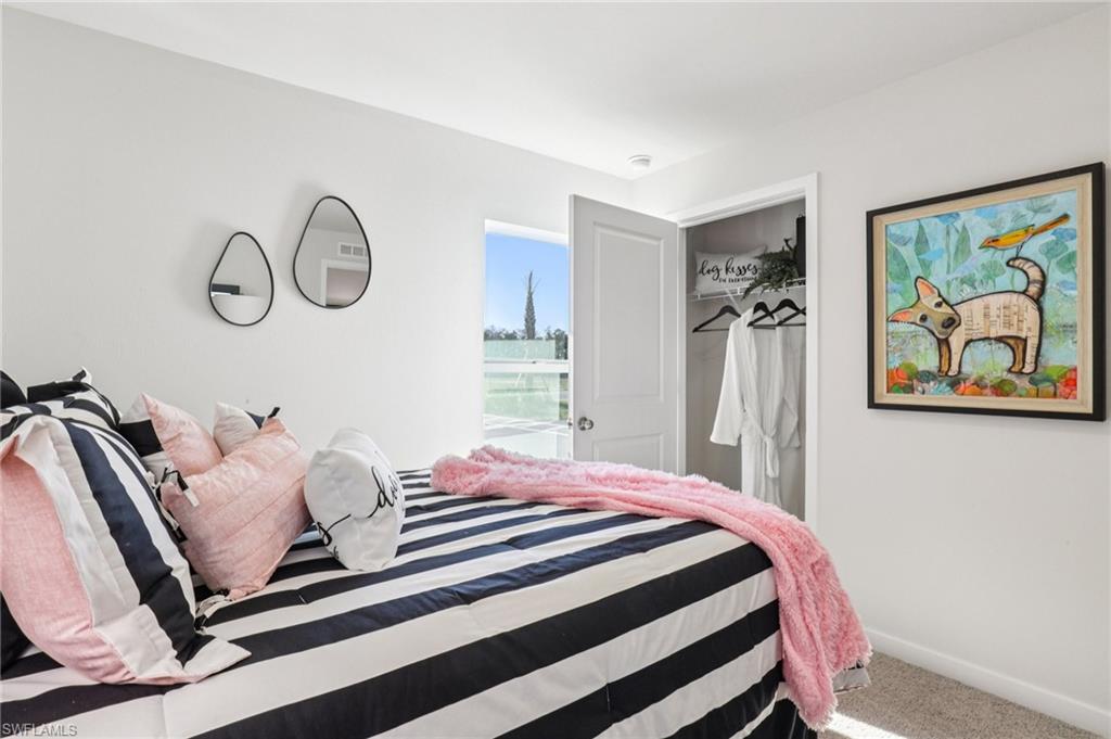 8022 Cedar Ky Way Lehigh Acres, FL 33971 - Photo 19 of 45 a bedroom with a bed and a painting on the wall