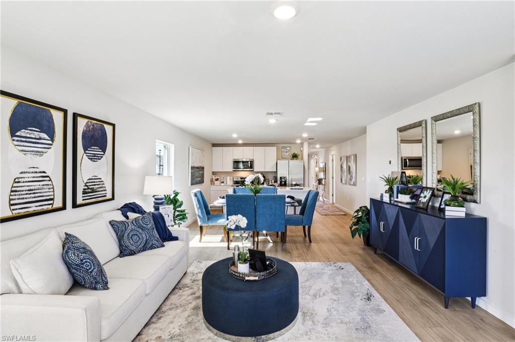 8022 Cedar Ky Way Lehigh Acres, FL 33971 - Photo 5 of 45 a living room with furniture a wooden floor and a chandelier