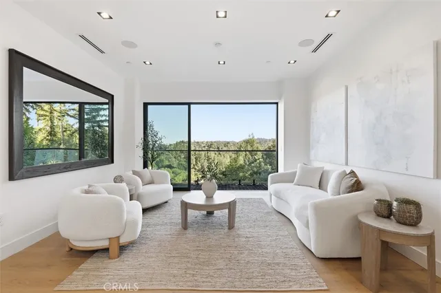 a kitchen island with stainless steel appliances a table chairs refrigerator and a sink