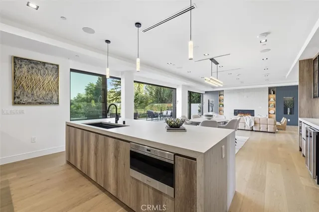 a kitchen with granite countertop a table chairs stove and white cabinets