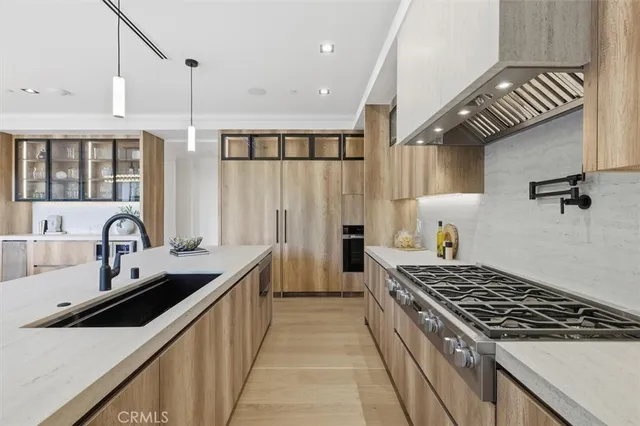 a living room with stainless steel appliances kitchen island granite countertop a refrigerator and a sink