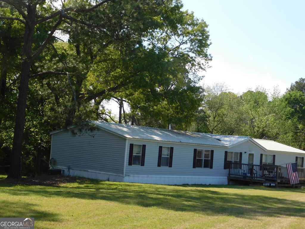940 Clifford Meeks Road Collins, GA 30421 - Photo 1 of 1 a front view of a house with a garden and tree