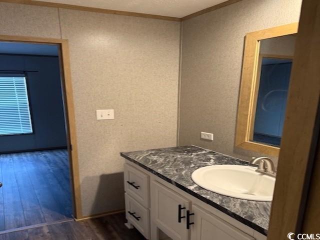 65 Clemmons Drive Tabor City, NC 28463 - Photo 21 of 29 Bathroom featuring vanity, wood finished floors, crown molding, and a textured wall