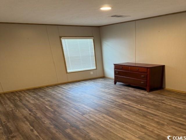 65 Clemmons Drive Tabor City, NC 28463 - Photo 25 of 29 Empty room featuring wood finished floors, crown molding, baseboards, and recessed lighting