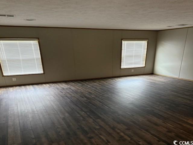 65 Clemmons Drive Tabor City, NC 28463 - Photo 26 of 29 Empty room with dark wood finished floors and a textured ceiling