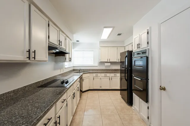 a kitchen with stainless steel appliances granite countertop a refrigerator and a sink