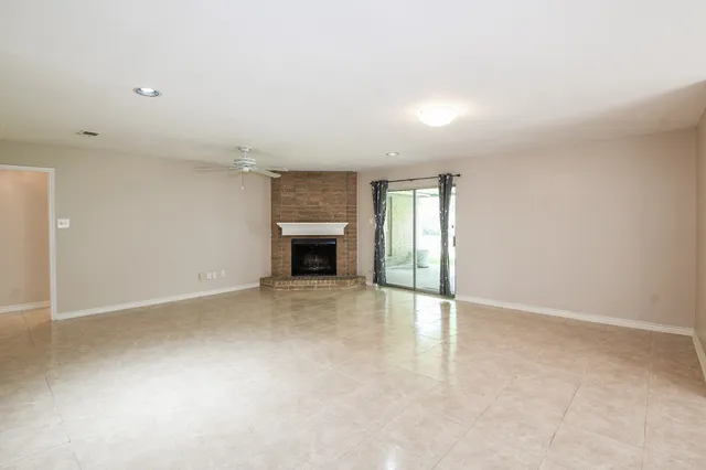 an empty room with fireplace and windows