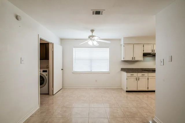 an empty room with a kitchen and a sink
