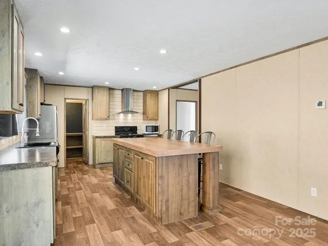 a kitchen with stainless steel appliances granite countertop a refrigerator a stove and a sink