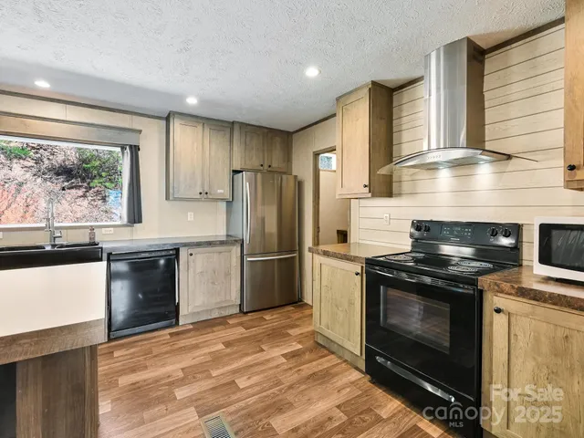 a kitchen with a stove a refrigerator and a stove top oven