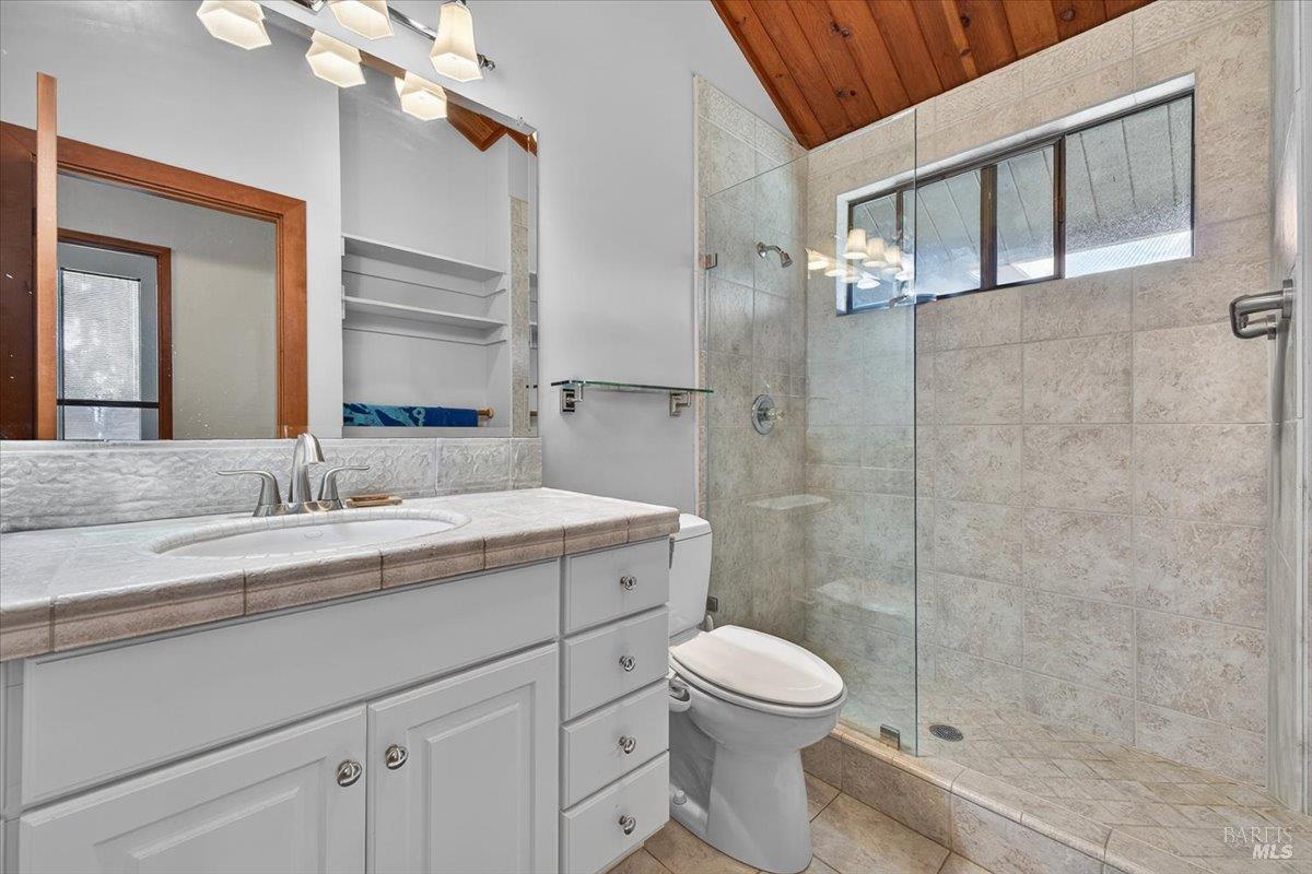 23881 Walling Road Geyserville, CA 95441 - Photo 13 of 40 a bathroom with a granite countertop sink a toilet and a mirror