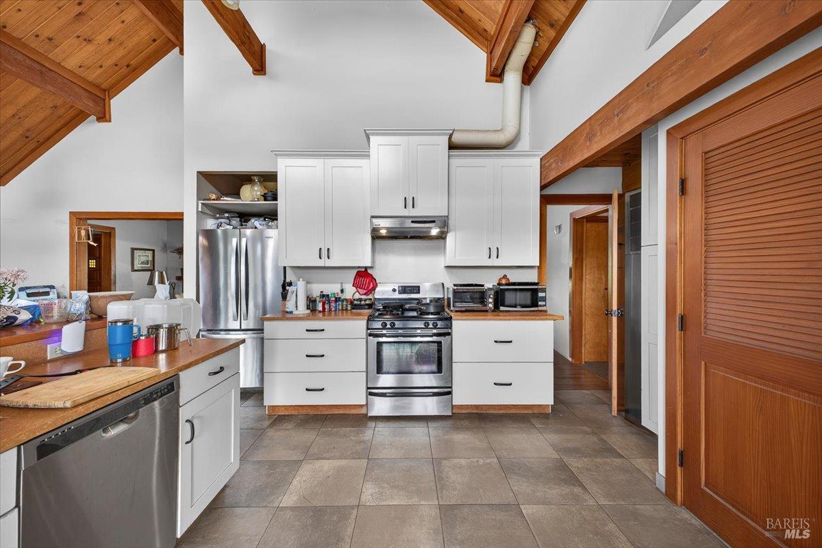 23881 Walling Road Geyserville, CA 95441 - Photo 9 of 40 a kitchen with white cabinets and white appliances