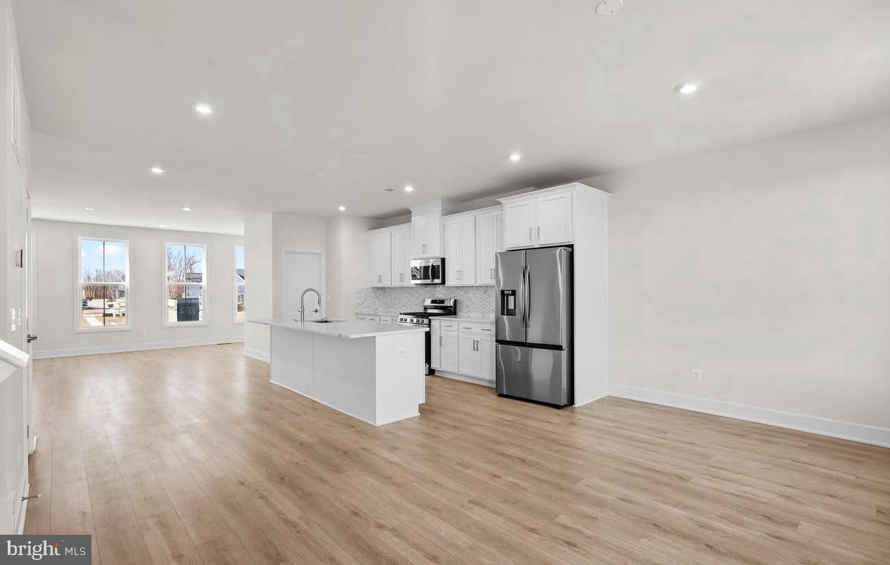 109 Galaxy Place Stephenson, VA 22656 - Photo 6 of 25 an open kitchen with white cabinets and stainless steel appliances
