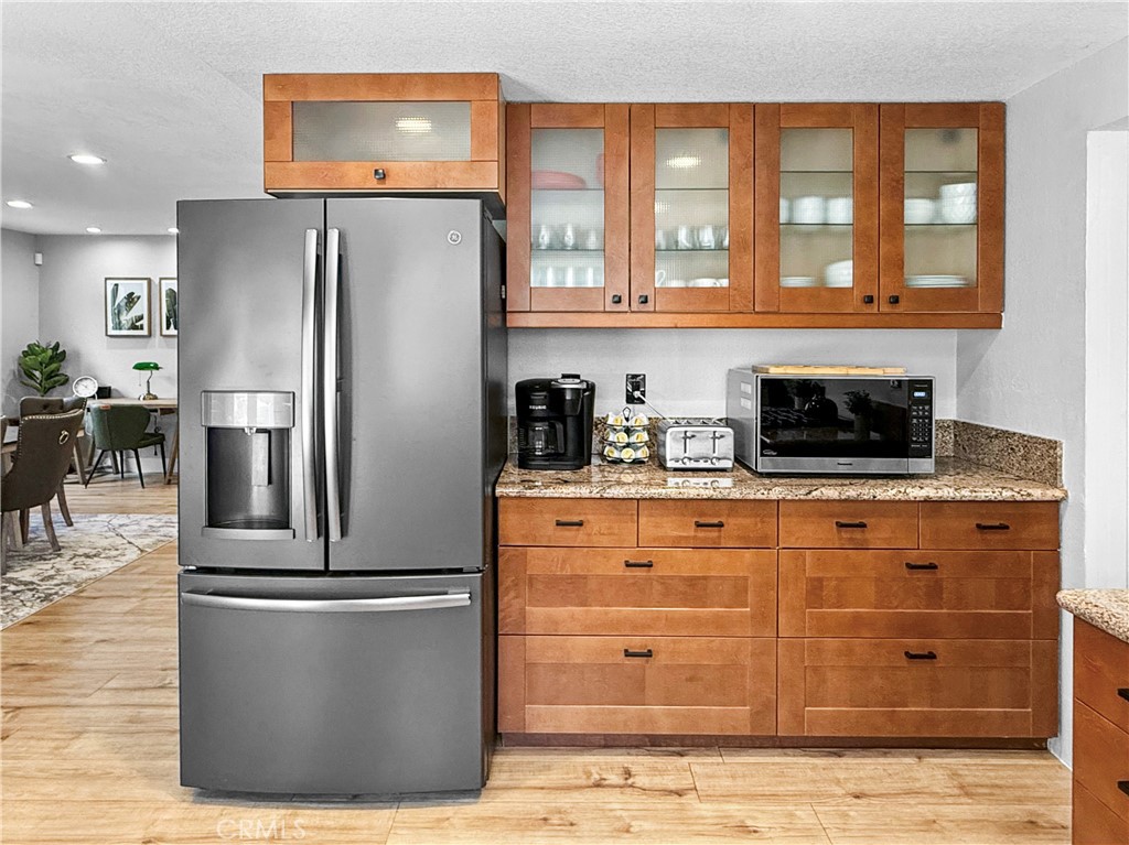 16955 Lake Knoll Parkway Riverside, CA 92503 - Photo 19 of 42 a kitchen with stainless steel appliances granite countertop a refrigerator a stove and a sink with wooden cabinets