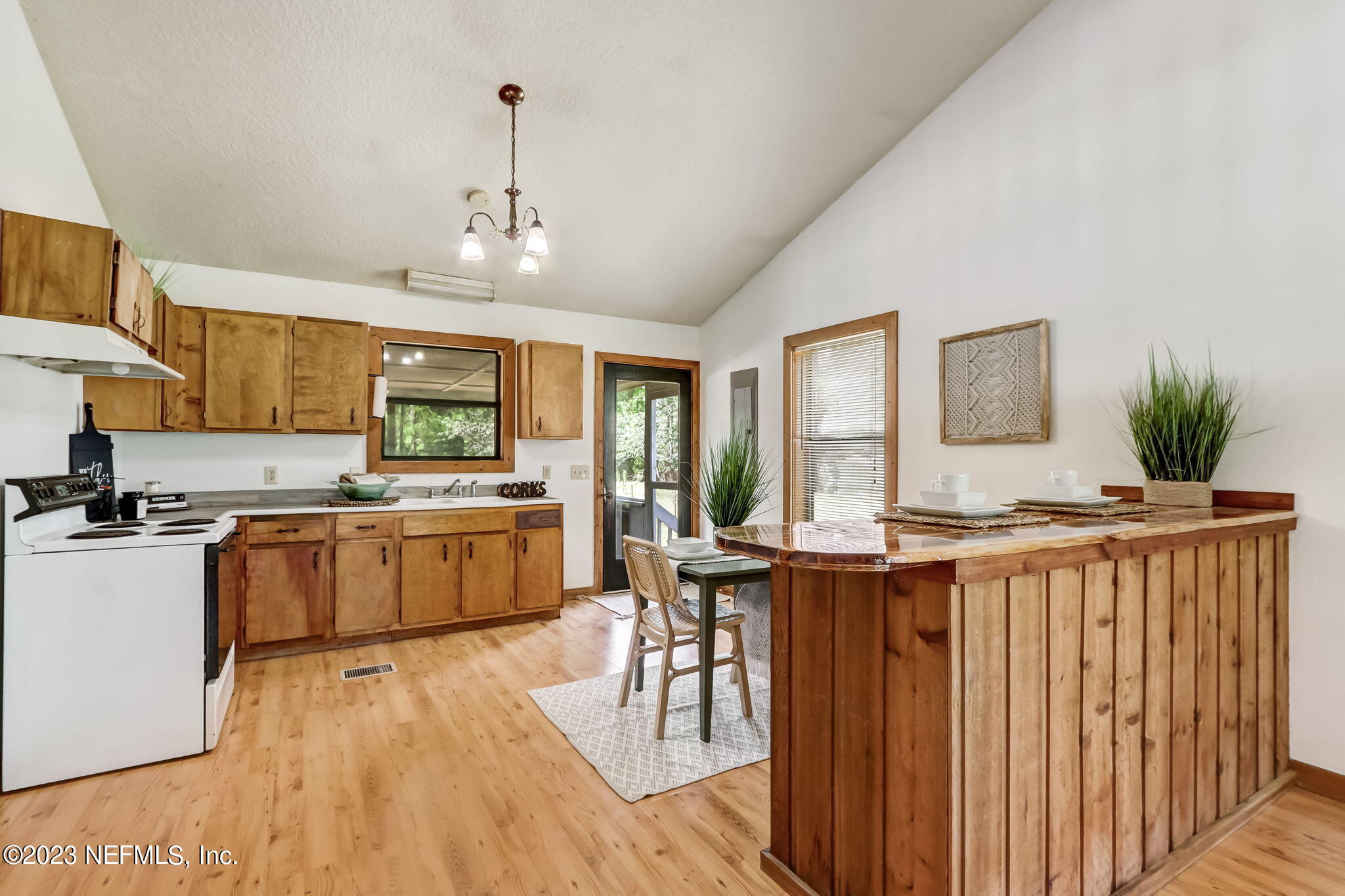 86105 Pages Dairy Road Yulee, FL 32097 - Photo 11 of 39 a kitchen with stainless steel appliances granite countertop a stove top oven a sink dishwasher and a dining table with wooden floor