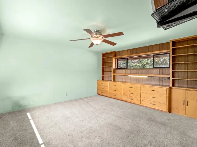 an empty room with chandelier fan