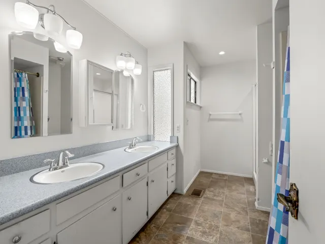 a bathroom with double sink and a mirror