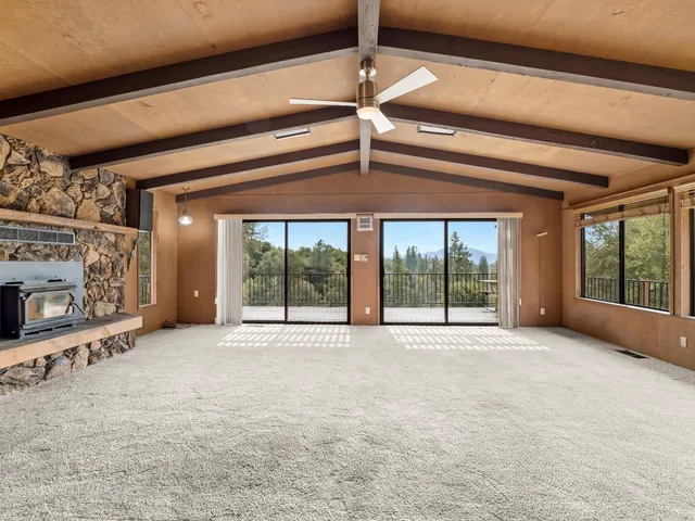 a view of an empty room with a fireplace and a window