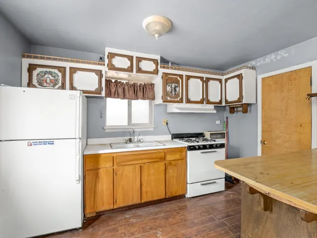 a kitchen with stainless steel appliances granite countertop a stove a refrigerator and a sink