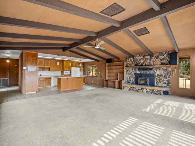 a view of an empty room with fireplace and a window