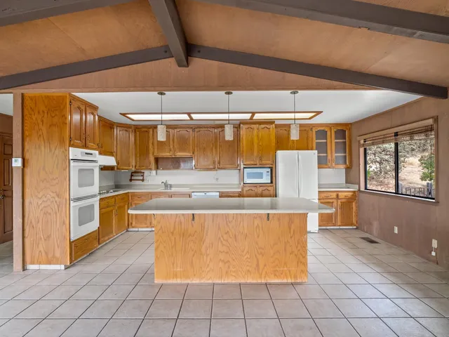 a large kitchen with stainless steel appliances kitchen island granite countertop a large counter top and cabinets