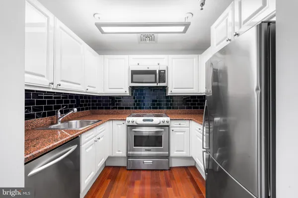 a kitchen with stainless steel appliances granite countertop a stove a refrigerator and a sink