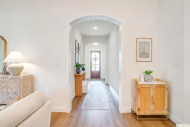 a hall way with wooden floor and cabinet