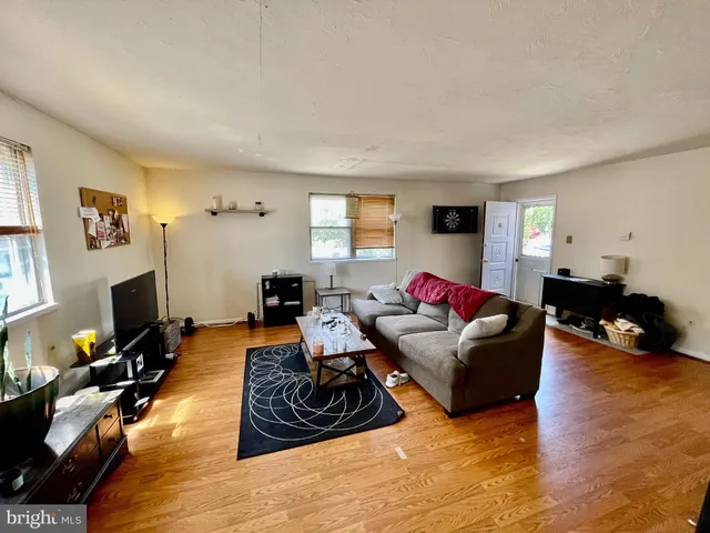 a living room with furniture a flat screen tv and a window